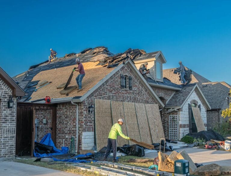 Workers engage in roof replacement on a brick house in Fort Worth, Texas.